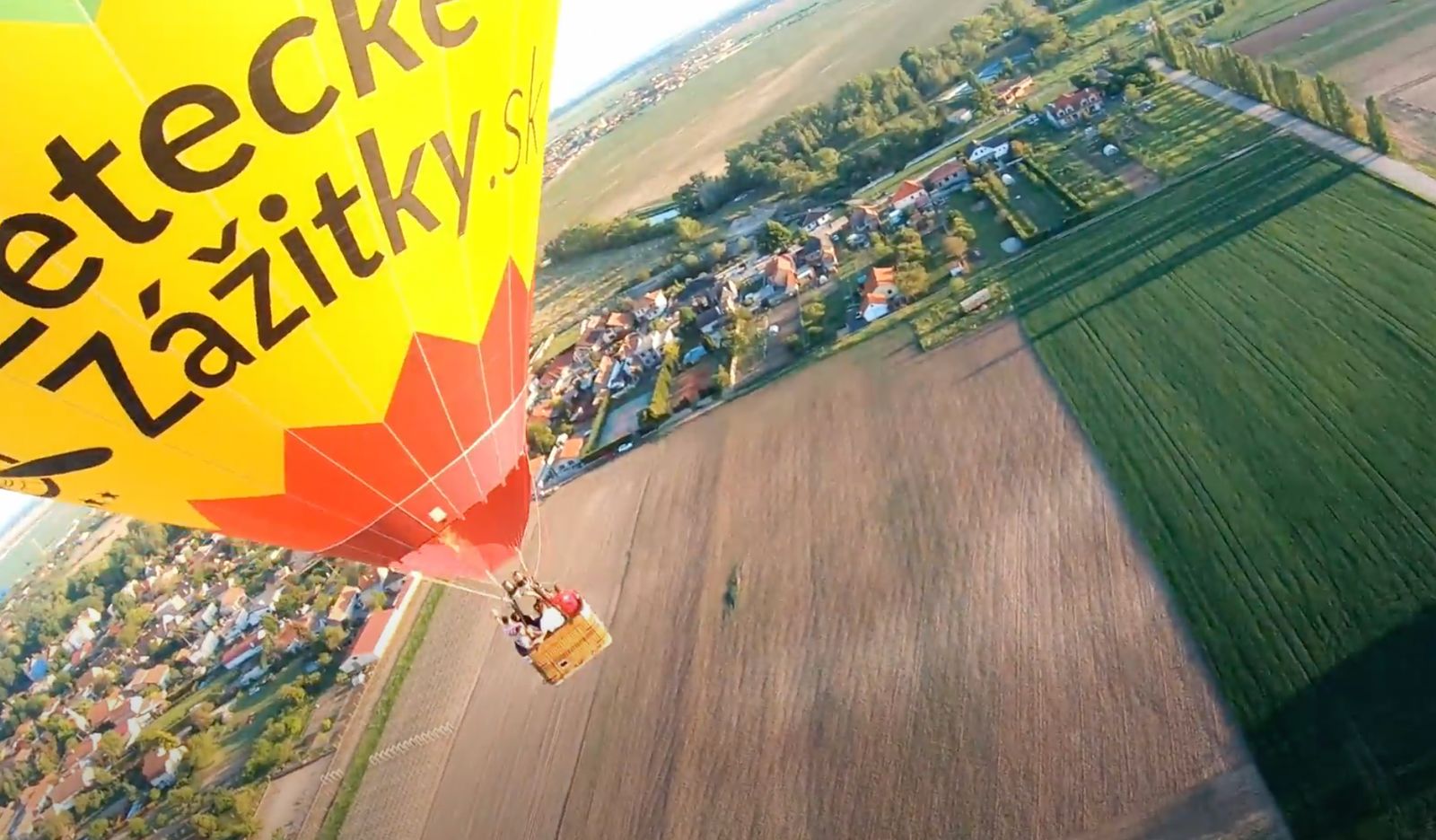 Pohľad z FPV dronu na teplovzdušný balón s pasažiermi – unikátna perspektíva leteckého zážitku.