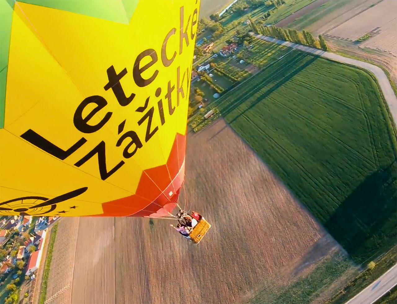 Balón počas letu nad slovenskými dedinkami – pohľad z dronu zachytáva pokojný let a výhľady do krajiny.