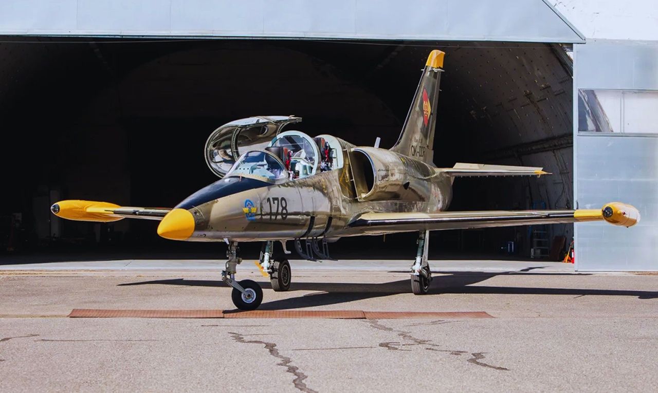 Prúdové lietadlo L-39 Albatros pred hangárom s otvorenou kabínou – ikonický stroj na let prúdovým lietadlom.