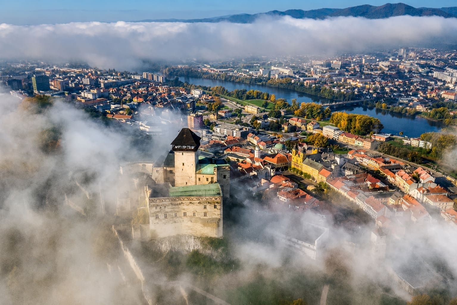 Trenčiansky hrad z vtáčej perspektívy počas vyhliadkového letu – panoráma mesta Trenčín a rieka Váh.